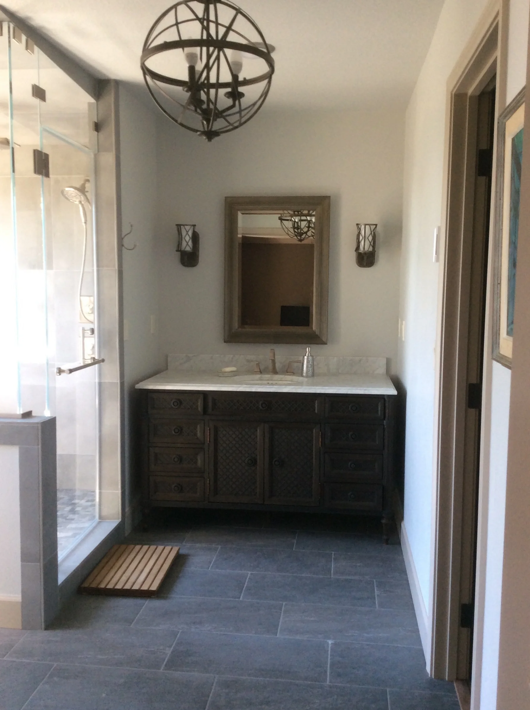 Bathroom with custom lighting fixtures and mirrors, wall sconces